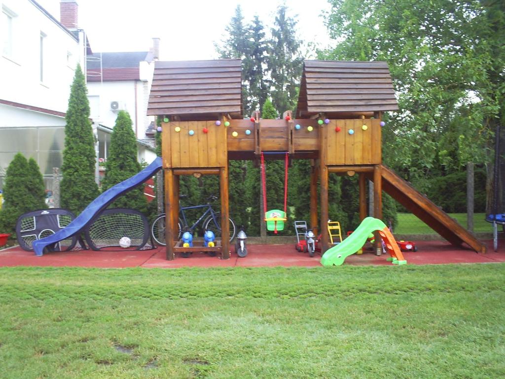 尼赖吉哈佐Harmatcsepp Apartmanház的庭院中一个带木游戏结构的游乐场
