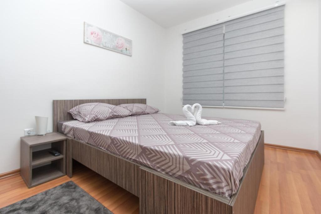 萨拉热窝Apartman Emir 1的卧室里设有一张床上,上面有一只白色填充动物
