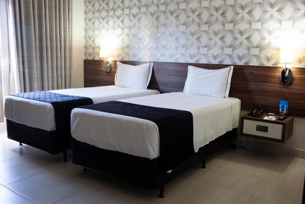 库亚巴德卢卡酒店的两张位于酒店客房的床,配有两张sidx sidx单人床