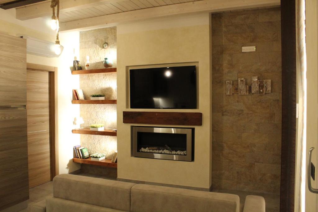 代森扎诺-德尔加达Villa Martina的一间带电视和壁炉的客厅