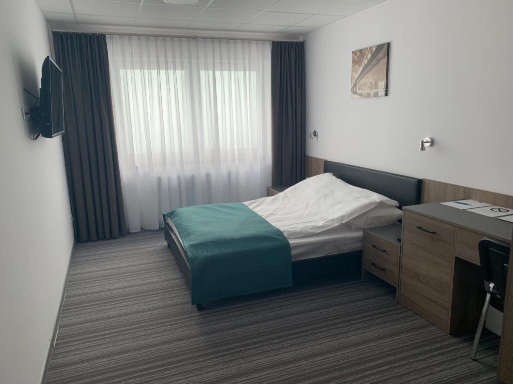 克拉科夫Pokoje gościnne Hut Pus的酒店客房配有一张床、一张书桌和一张书桌。