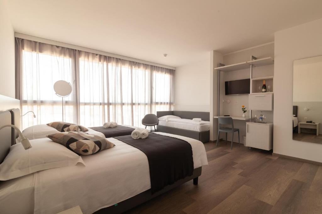 门德里西奥Hotel Albergo Milano的白色卧室配有一张大床和一张书桌