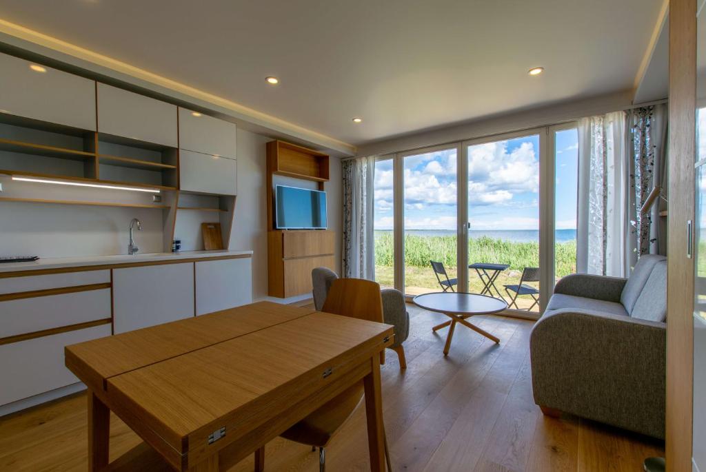 库雷萨雷Modern Sea View Apartments by Villa Kuus Sõlme的厨房以及带桌子和沙发的客厅。