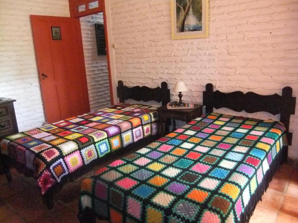 圣米格尔-阿尔坎茹Eco Pousada Passaredo的两张睡床彼此相邻,位于一个房间里