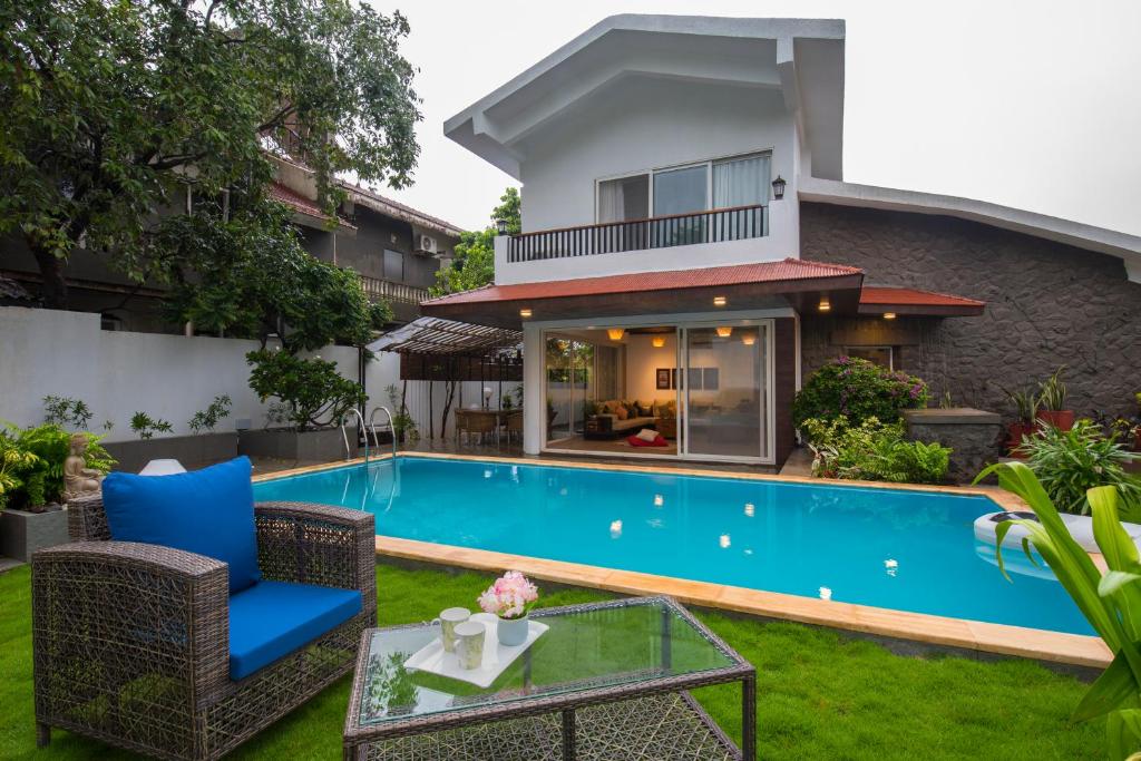 罗纳瓦拉EL Lodge by StayVista - Pool, lawn, and a charming gazebo for your perfect getaway的别墅后院的游泳池
