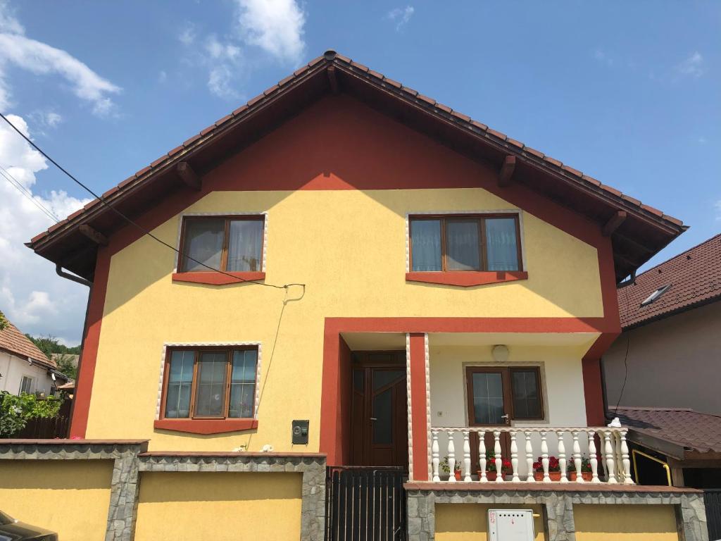 克利默内什蒂Casa Flori的黄色和橙色的房子设有阳台