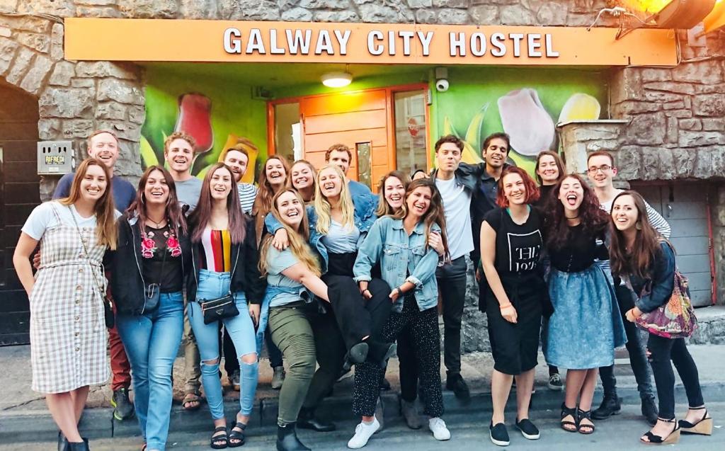戈尔韦Galway City Hostel - Solo Traveller Hostel的一群人站在一座建筑物前摆着一张照片
