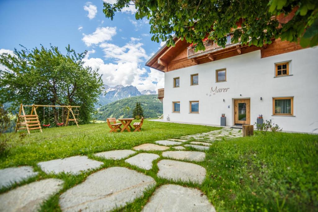 维拉巴萨Agriturismo MARER Urlaub auf dem Bauernhof的房屋前的石头路径,房屋前有游乐场