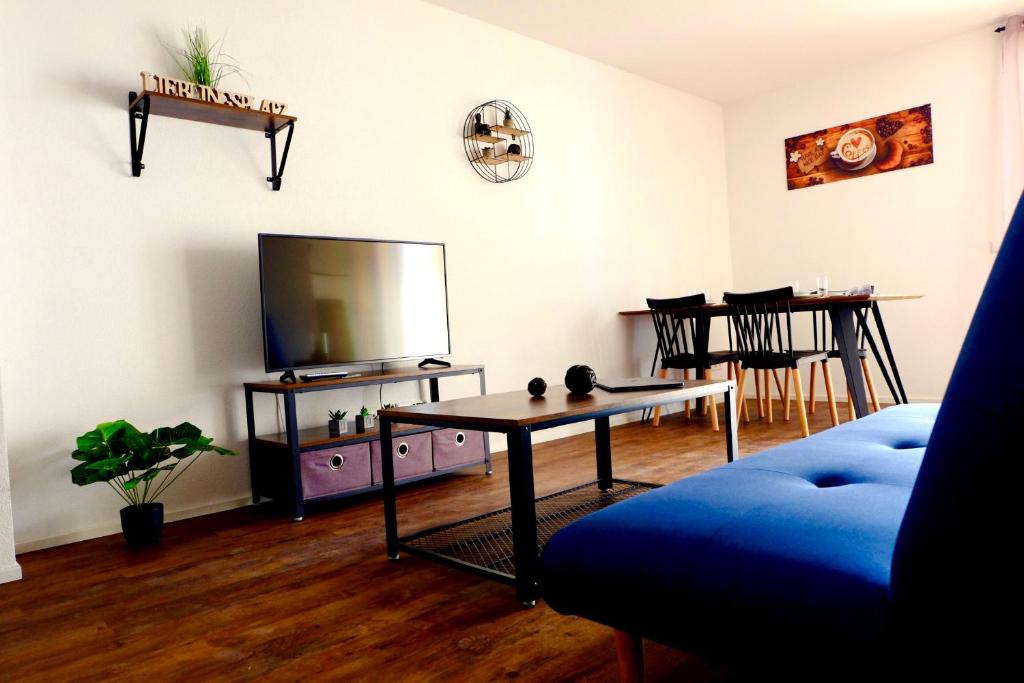 莱茵豪森Sweet Park Appartements的客厅配有电视和桌子