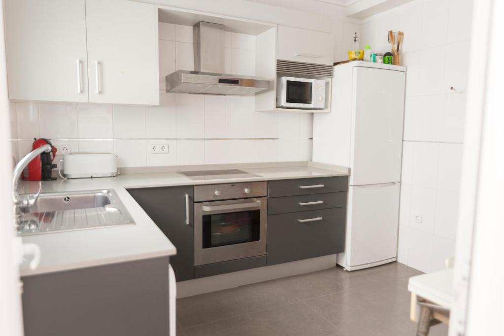 布尔哈索特Vacaciones en Valencia的白色的厨房配有水槽和冰箱
