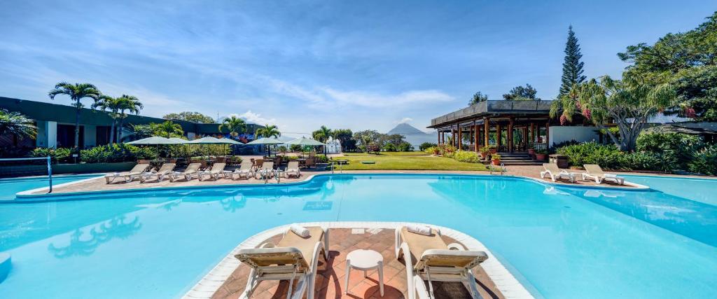 帕纳哈切尔波塔湖酒店的一个带椅子的大型游泳池,一个度假村