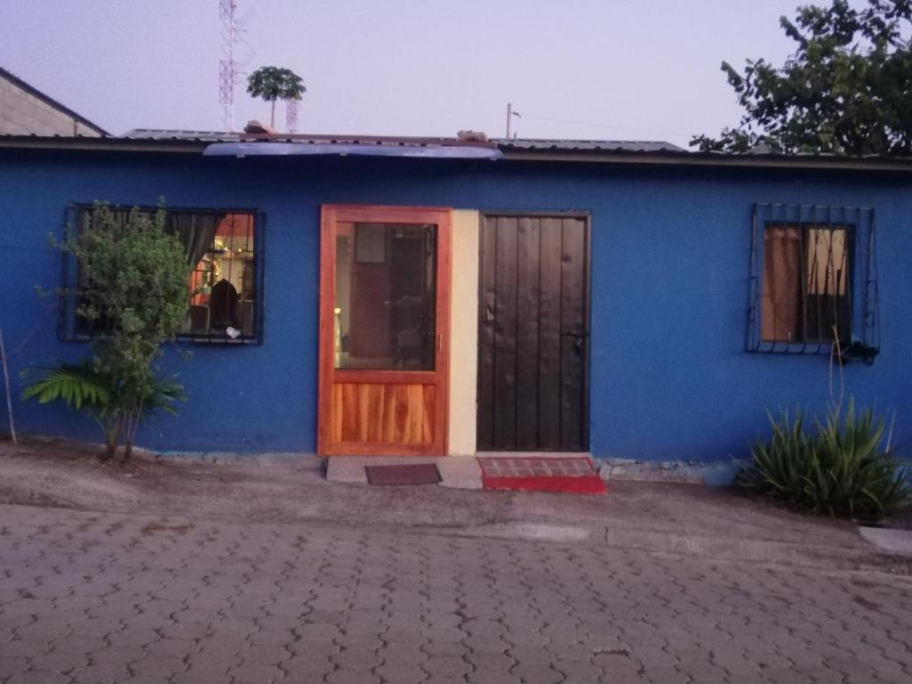 圣克里斯托瓦尔Hospedaje Arvakeni的蓝色的房子,设有木门和窗户