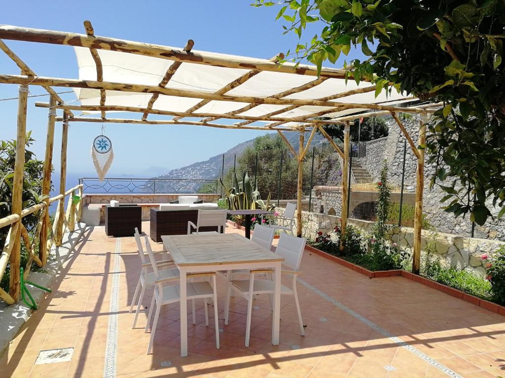 康加德马里尼Villa Donna Antonia - Amalfi Coast的凉亭下带桌椅的天井
