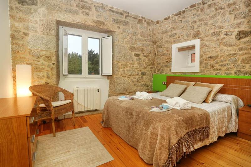 帕拉斯德丽A Casa do Avó的一间卧室配有一张床、一张桌子和石墙