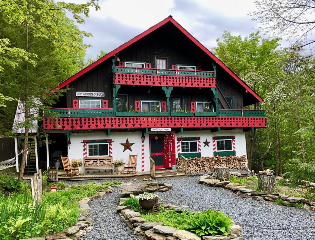 沃特伯里Grunberg Haus Inn & Cabins的一座红色和白色的房子,前面有一个花园