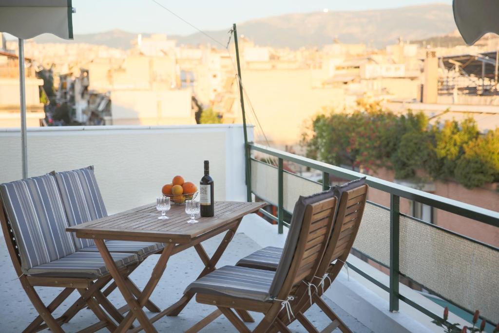 雅典ivannas penthouse的阳台上的桌椅和一瓶葡萄酒