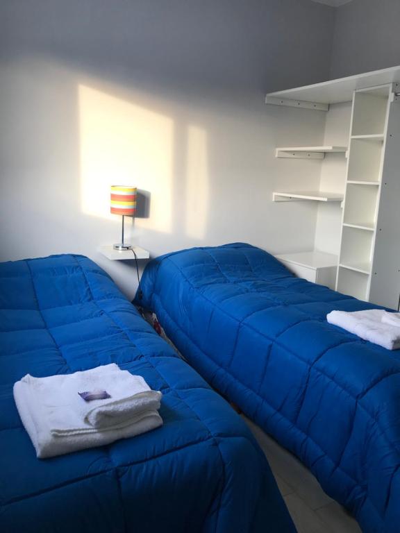 查斯科穆斯Departamento en Chascomús a dos cuadras de laguna的一张蓝色的沙发,坐在带灯的房间