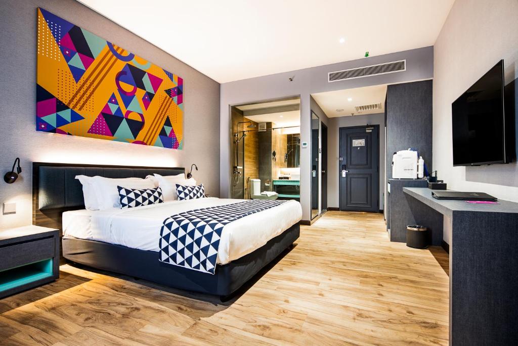 新山TROVE Johor Bahru的一间卧室配有一张特大号床和一台平面电视