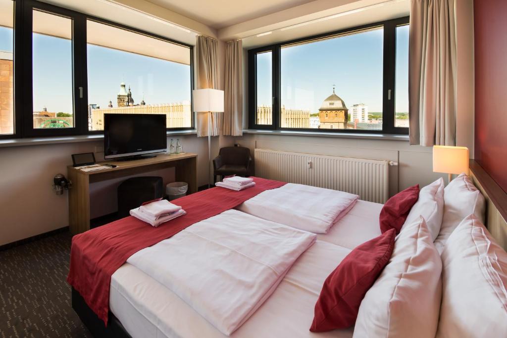 开姆尼茨比恩多酒店的酒店客房设有两张床、一张书桌和窗户。