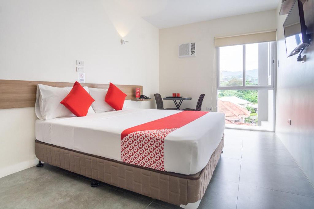 宿务18 Suites Cebu的一间卧室配有一张带红色枕头的大床