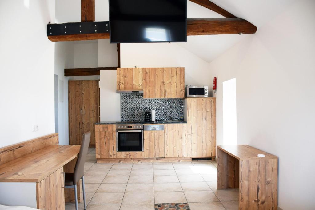 马希特伦克Apartment´s Marchtrenk的厨房配有木制橱柜、桌子和电视。