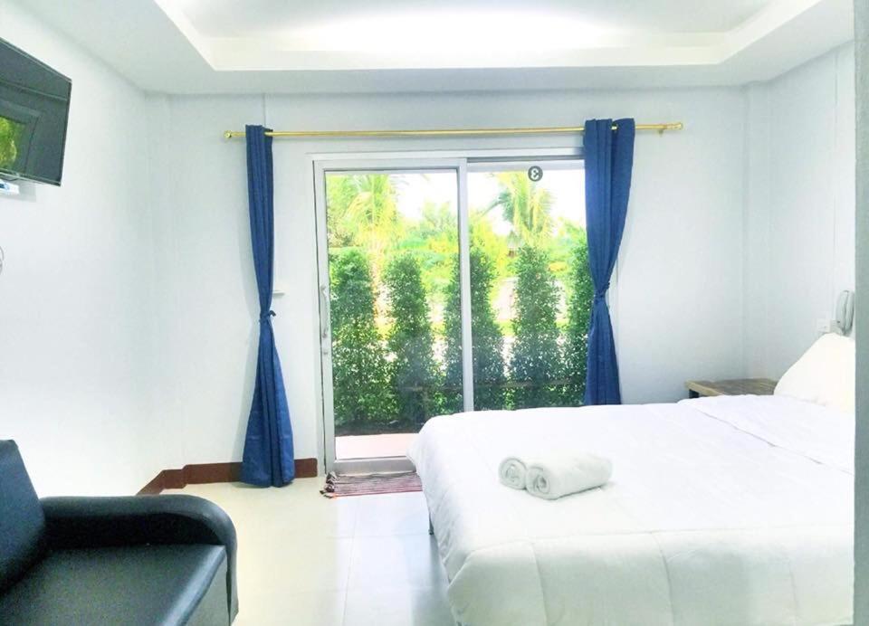 坤西育府Valee home & food的一间卧室配有床和蓝色窗帘的窗户