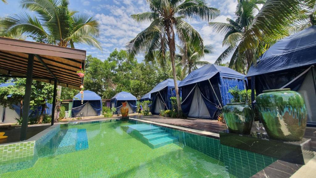 春蓬Moonshine Resort Chumphon的一个带蓝色帐篷游泳池的度假酒店