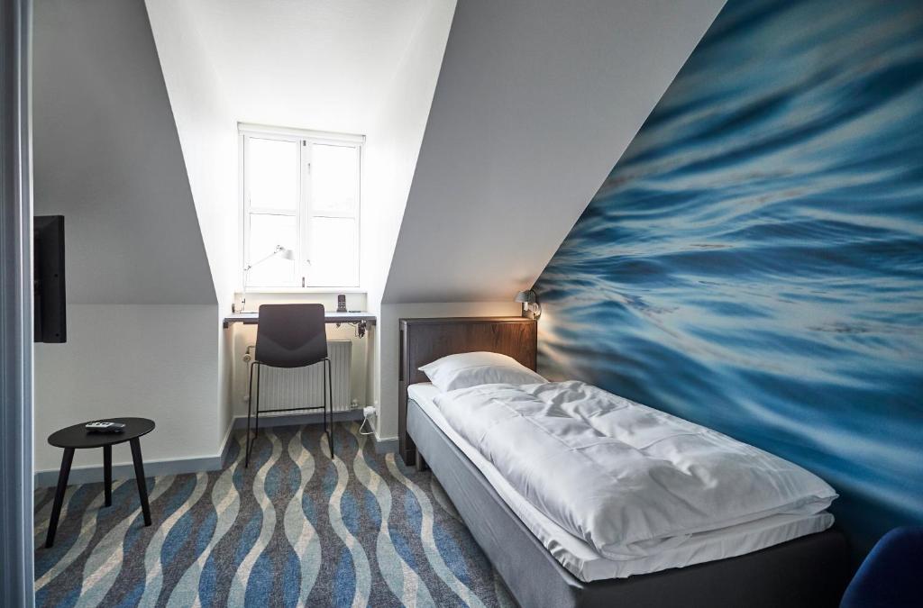 锡尔克堡维特斯胡斯会议中心酒店的一间卧室配有一张壁画床