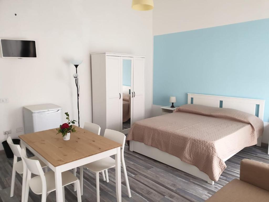 利帕里Lipari Suite Apartament的卧室配有一张床和一张桌子及椅子