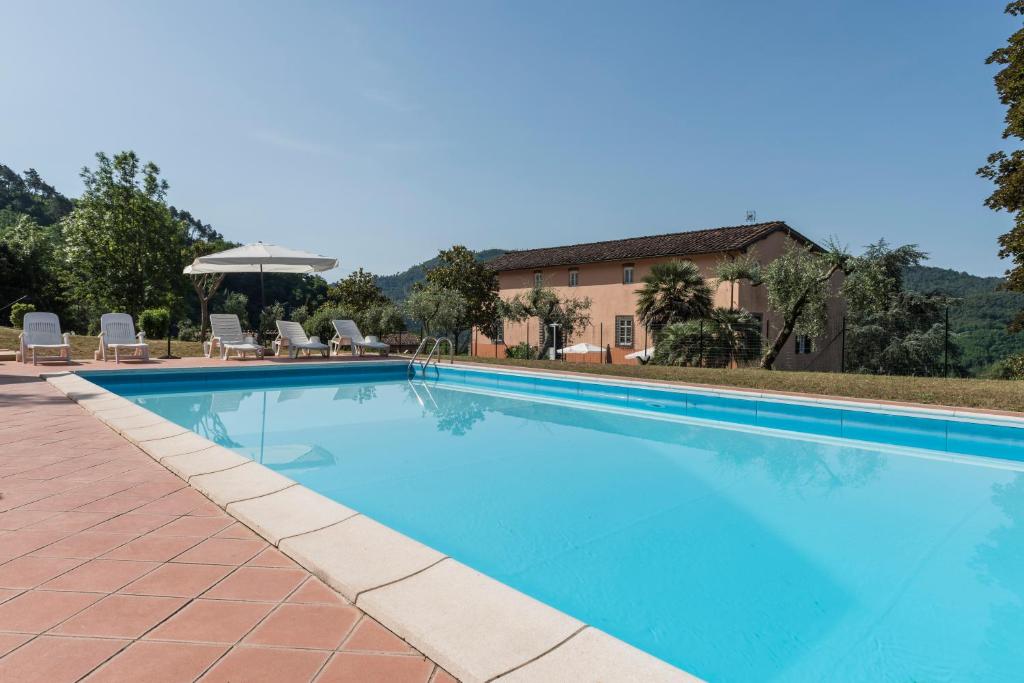 卢卡Bed and breakfast Villa Torre degli Onesti Apartments的一座带椅子的大型游泳池和一座建筑