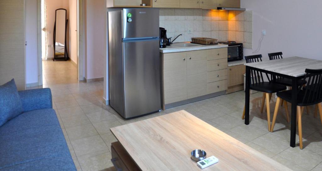 阿菲托斯Houses Nikolaos的厨房配有不锈钢冰箱和桌子