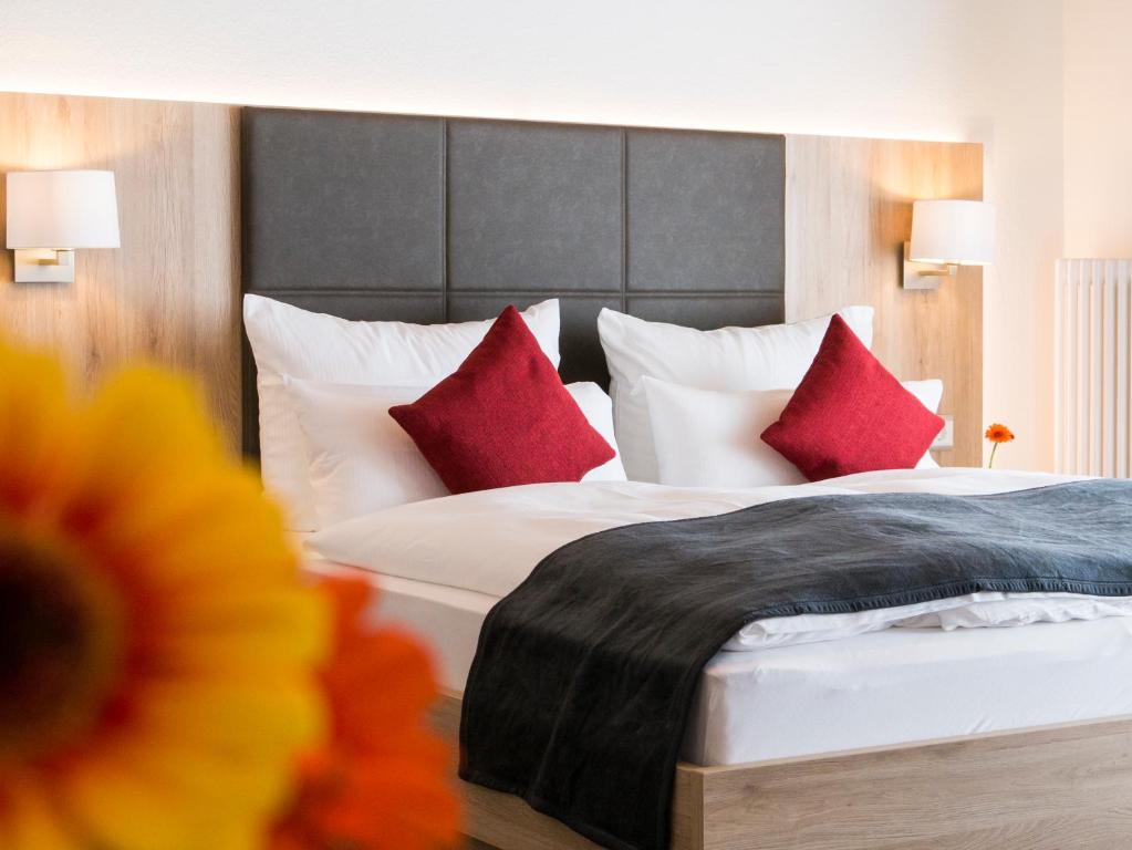 卡佩尔-格拉芬豪森Hotel Restaurant Schiff的配有红色枕头的床的酒店客房