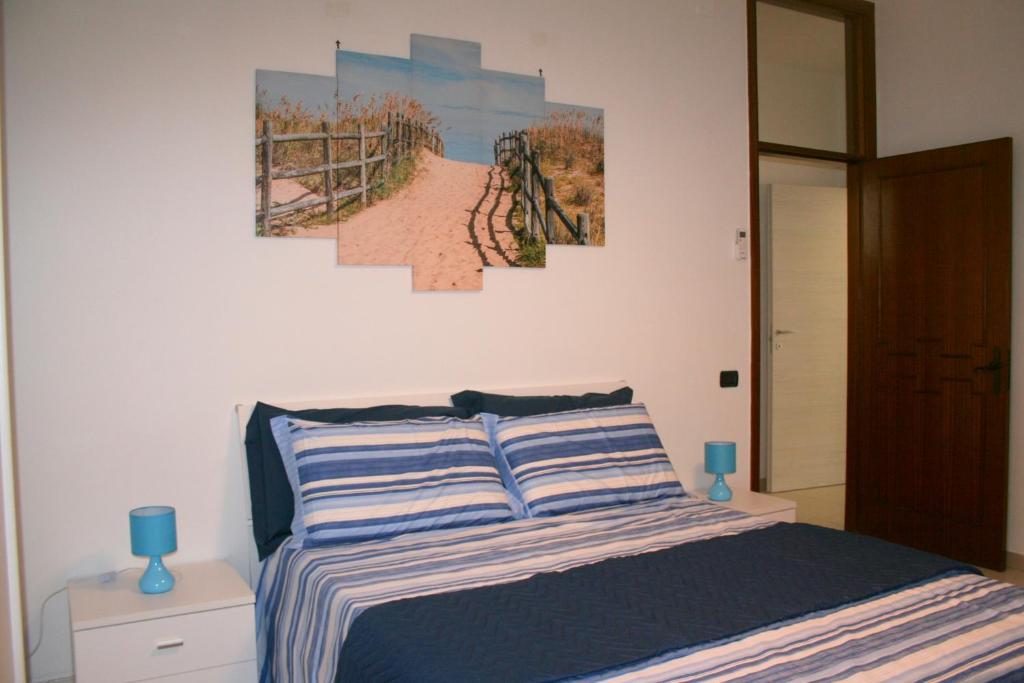 切萨雷奥港App.ti nel cuore di Porto Cesareo的卧室配有一张壁画和两张画的床铺。