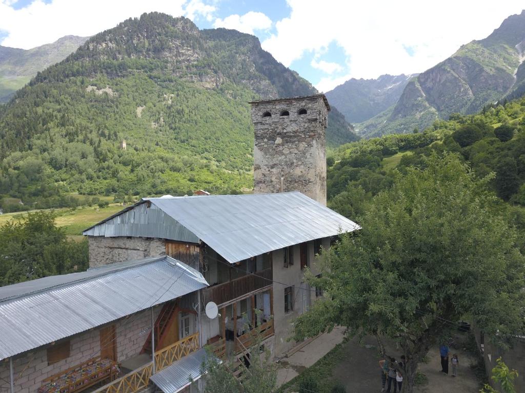 ZhabeshiGuest House Tengo的一座古老的石头建筑,塔楼和山地背景