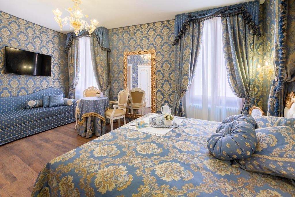 威尼斯Canal View San Marco Luxury Rooms的一间蓝色的卧室,配有床和客厅