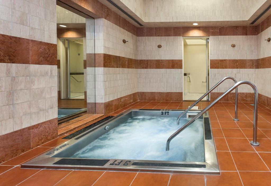 旧金山多纳特罗酒店的浴室设有热水浴缸和两面镜子