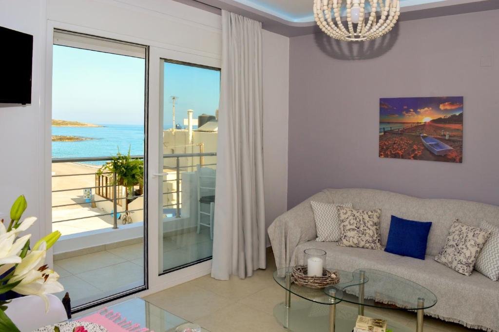 莫拉托斯Meltemi Beach Apartments的带沙发和玻璃桌的客厅