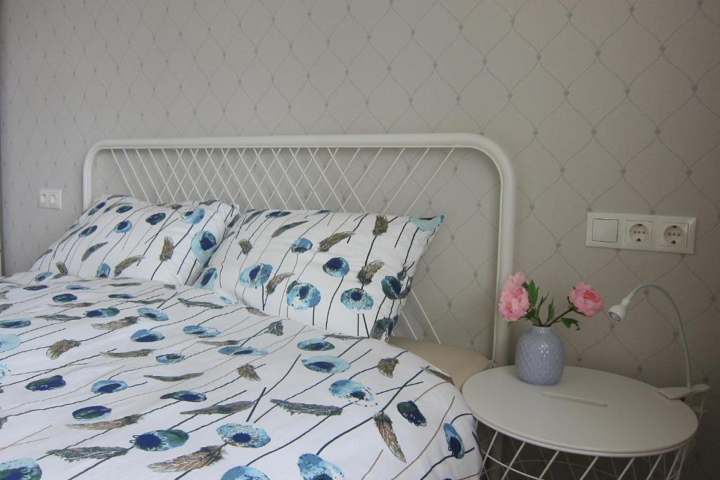 萨尔杜斯Apartment Anna的一张带蓝色花卉床罩和桌子的床