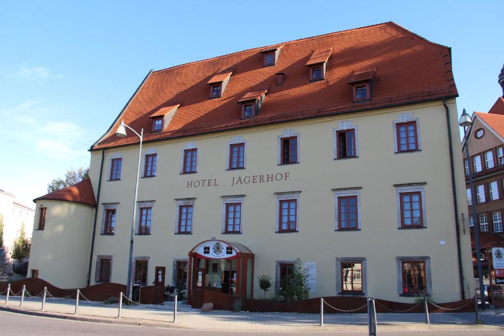 魏森费尔斯Ringhotel Jägerhof的一座白色的大建筑,有红色的屋顶