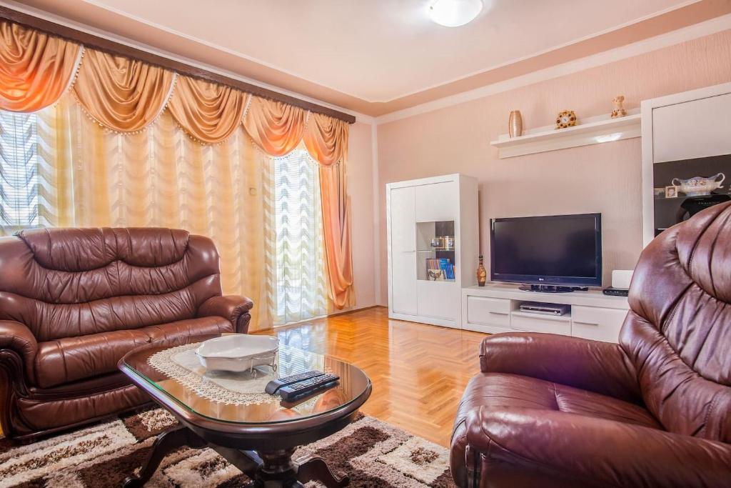 波德戈里察Luxury House Petrovic - Vranjina Skadar Lake的客厅配有皮革家具和平面电视