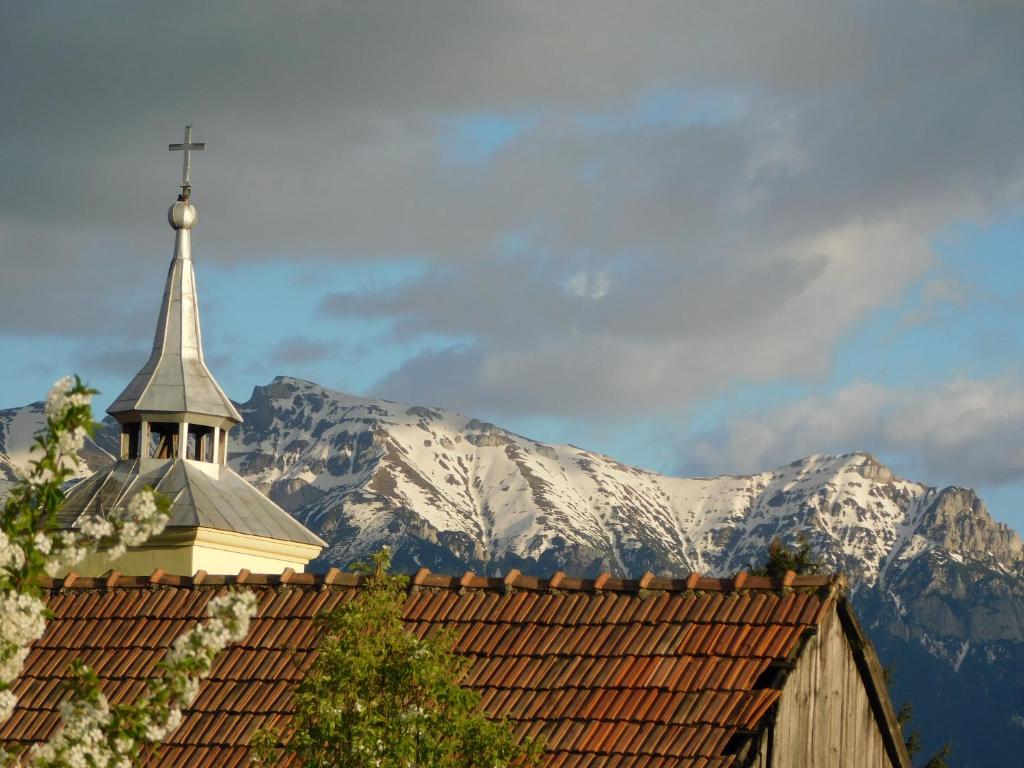 泽尔内什蒂Mountain Vista Suites的一座陡峭的教堂,一座雪覆盖的山