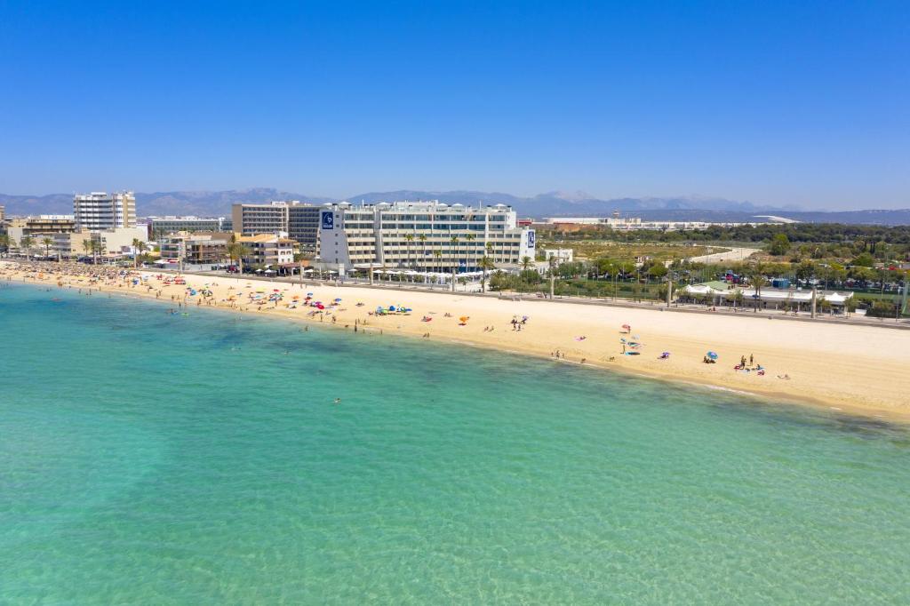 帕尔马海滩丰塔内利亚斯海滩公寓式酒店的一片有一群人的海滩和海洋