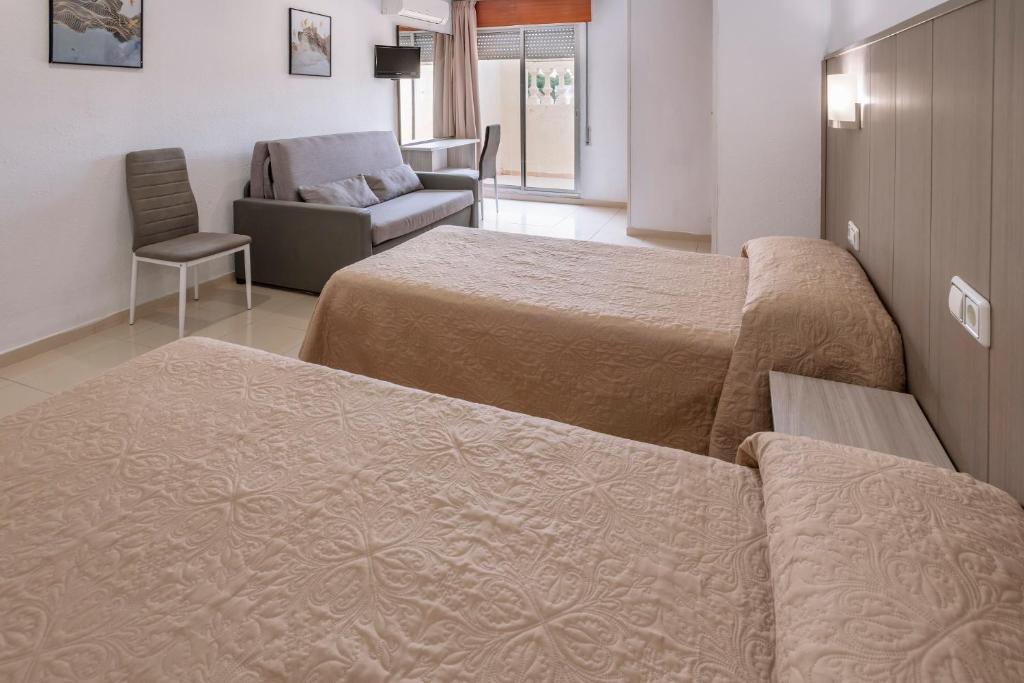 萨洛妮扎酒店的一间设有两张床、一张沙发和一把椅子的房间