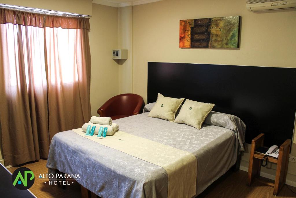 科尔多瓦阿尔托巴拉那酒店的一间卧室配有一张带椅子的床和一扇窗户