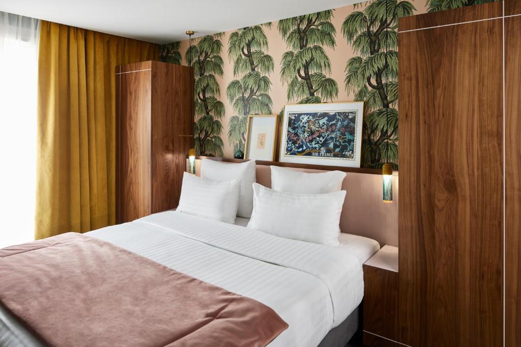 巴黎泰勒酒店的一间卧室配有一张带白色床单的大床