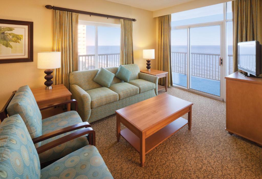 默特尔比奇Club Wyndham SeaWatch Resort的带沙发和电视的客厅以及阳台。