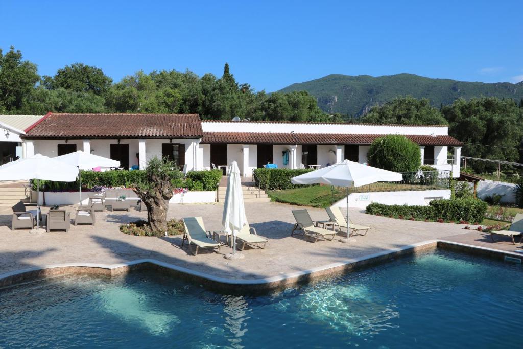 阿普索斯Summer Wine Friendly Resort的一个带遮阳伞和椅子的游泳池的度假酒店