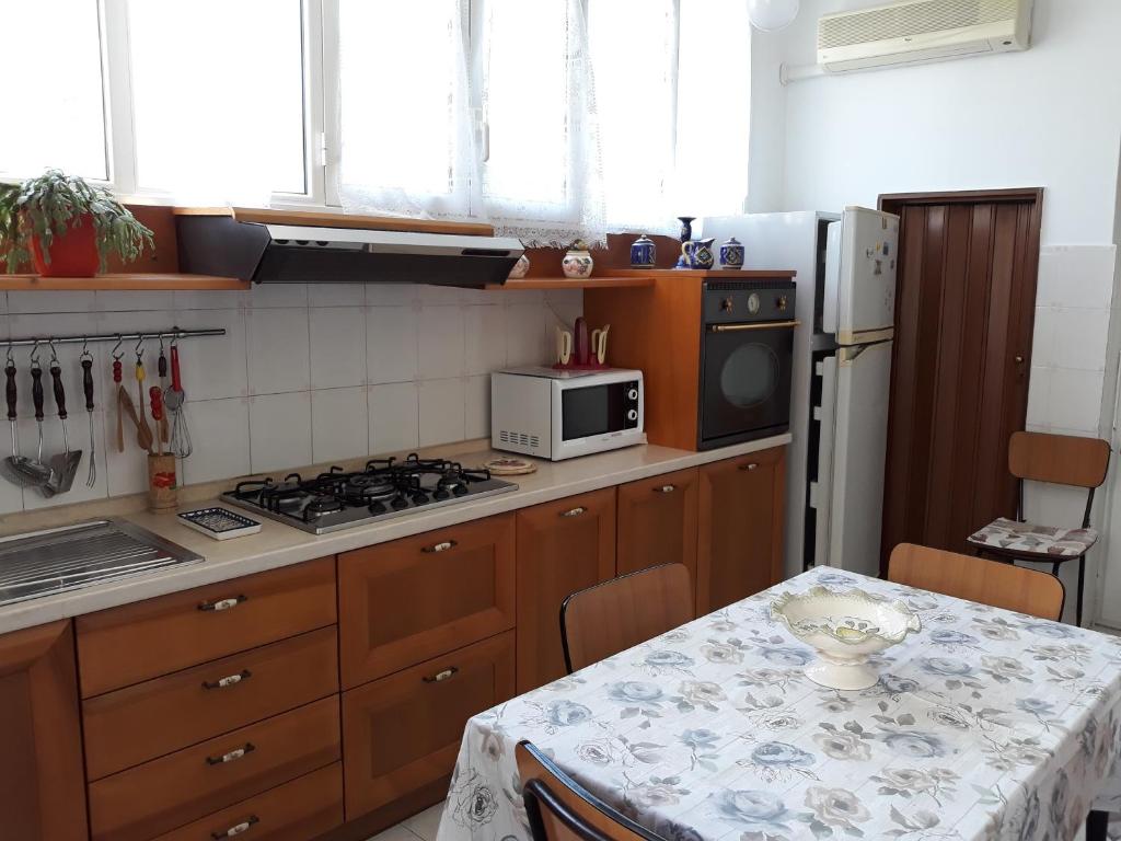 阿莱齐奥Casa vacanze Alezio的厨房配有桌子和炉灶。 顶部烤箱