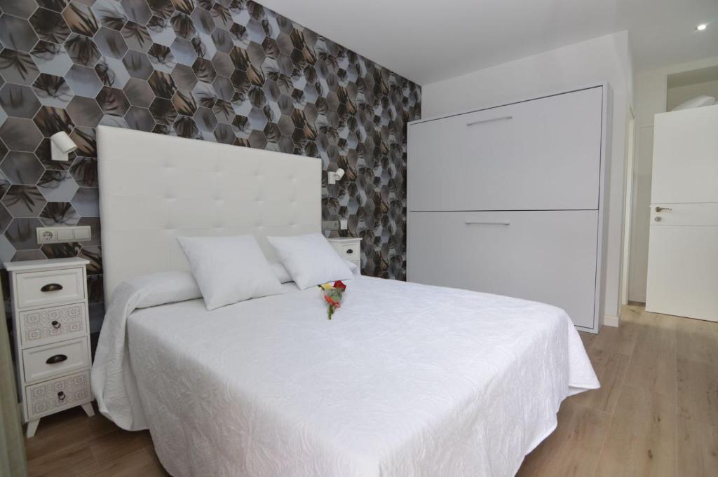 贝尼多姆Hotel Castillo Benidorm的白色的卧室设有白色的床和墙壁