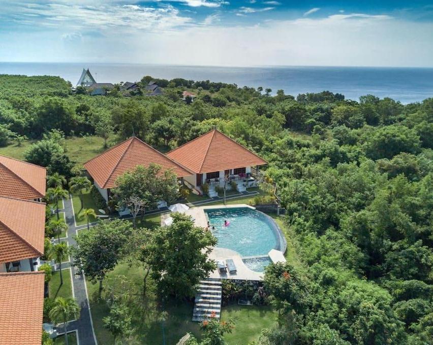 乌鲁瓦图Batu Jaran Hill Cottage Uluwatu的享有带游泳池的房屋的空中景致